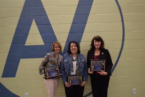 Julie McMurray, Laura Ross, Barbara (Goggin) Brooks in front of the AV blue and goldwall